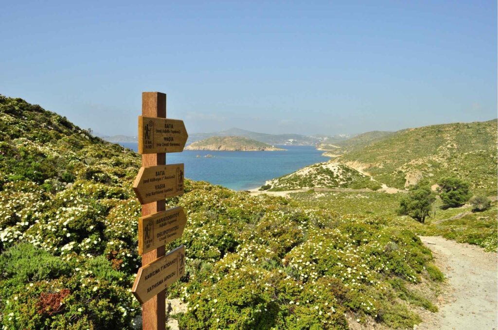 Wooden directional trail signs pointing along a coastal path in Patmos - Hike Greece
