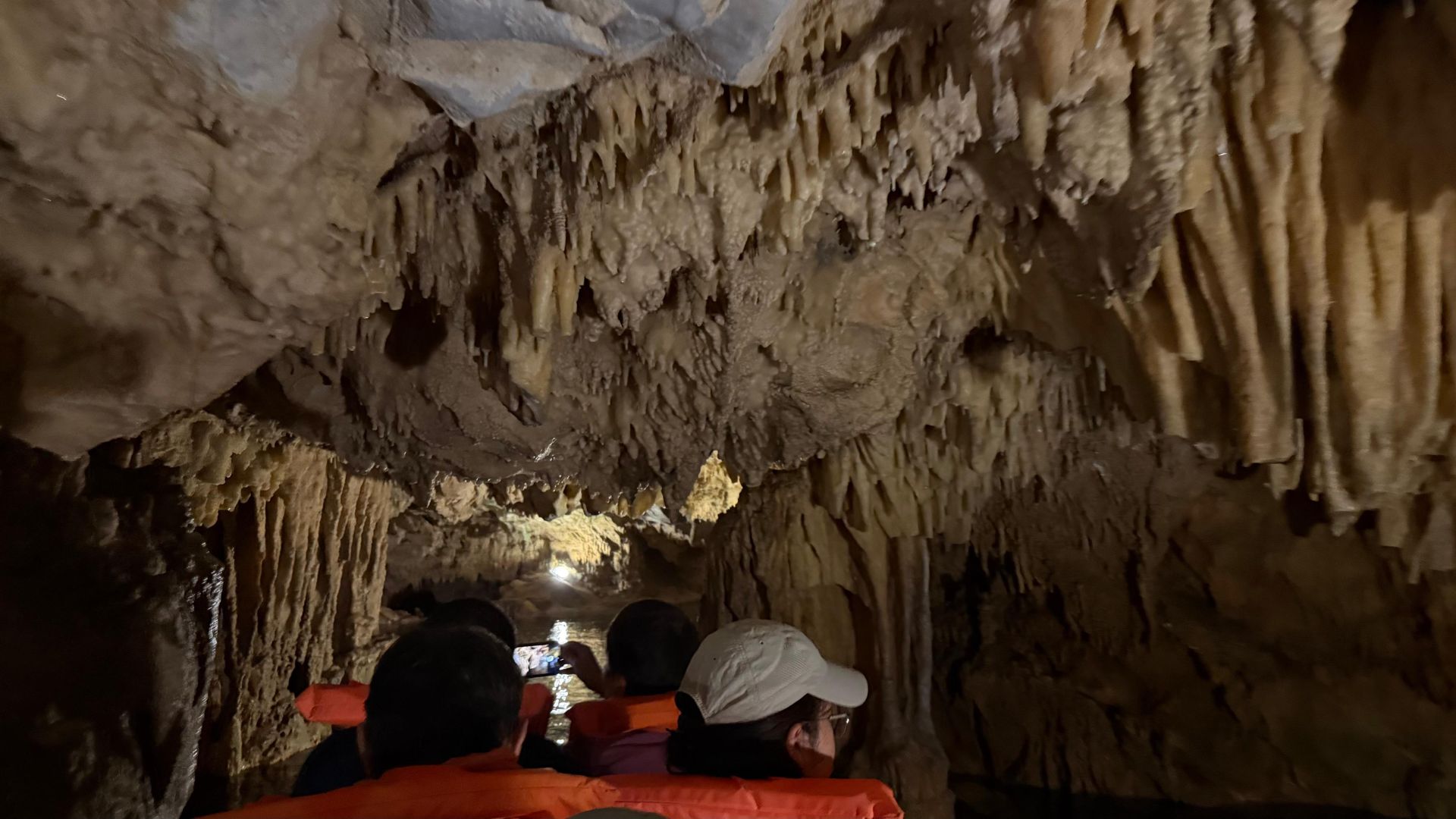 Visitors in life jackets on a boat inside the stalactite-filled Diros Caves in the Mani, Peloponnese