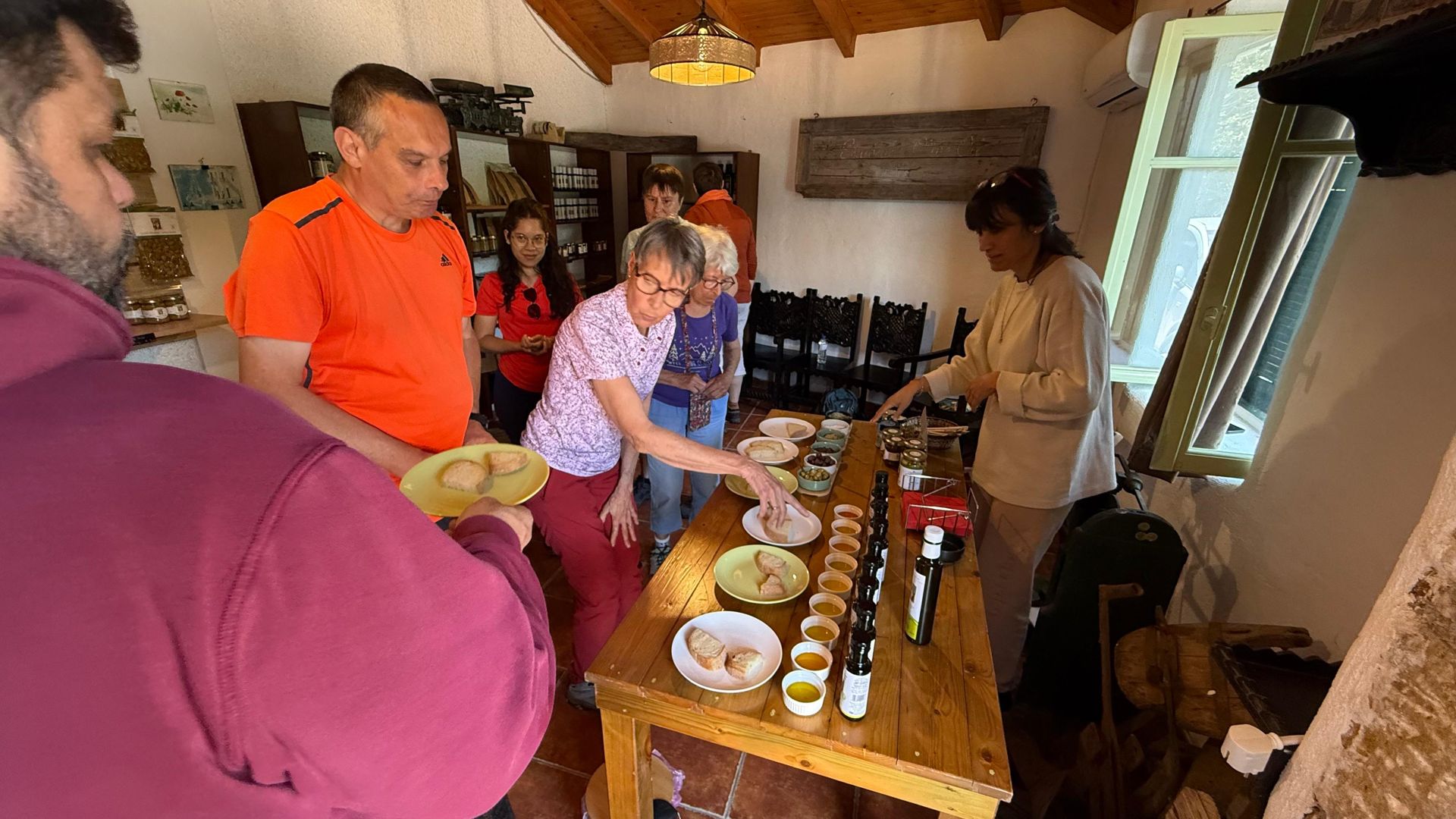 French-speaking hikers tasting olive oil and local products during a guided Peloponnese tour